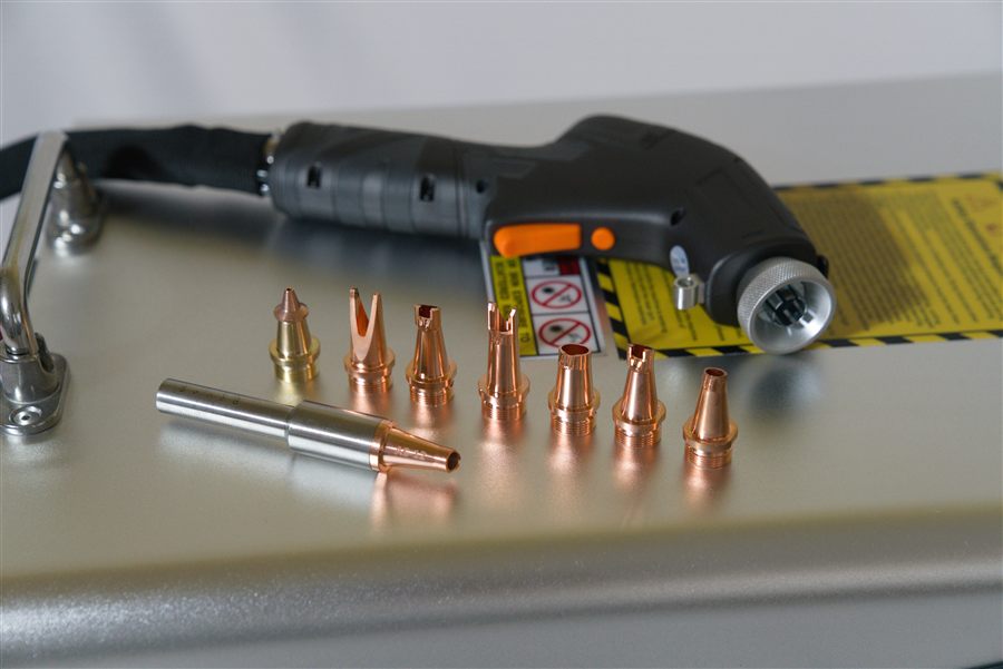 Copper welding nozzle kit laid out on top of the NX-1500 Air