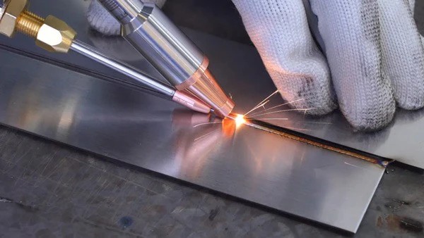 Handheld laser welding a seam with wire feed on brushed aluminum plate